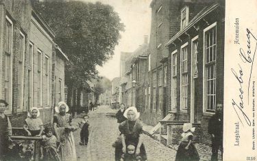 De Langstraat boven aan de Markt met rechts van de Marktpoortstraat de timmermanswinkel van timmermansbaas Abraham van Eenennaam met daarnaast de bakkerswinkel van z'n zoon Francois van Eenennaam. Links van de Marktpoortstraat op de hoek de bakkerswinkel van Christiaan Crucq.