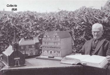 Adriaan Joosse lezend in de Croniek van Zeeland van Smallegange. Voor hem op tafel staan het door hem nagemaakte kerkgebouw, het oude stadhuis en het glazen huis.