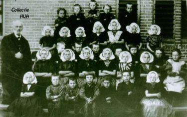 De oude bovenmeester Buys met een groep kinderen voor de school in 1895.