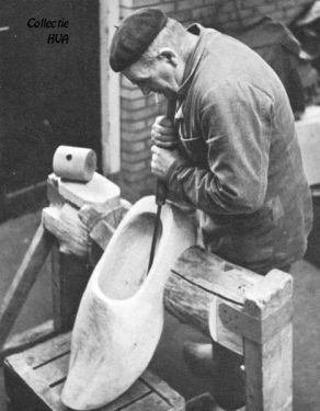 Klompenmaker De Klerk is druk bezig met een grote sierklomp.