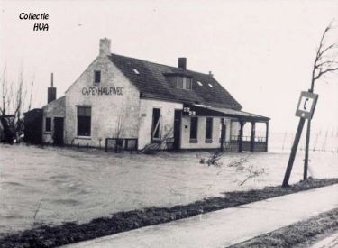 Café Halfweg aan de oude rijksweg loopt onder water. De voorgevel van het er tegenover staande huis stort in.