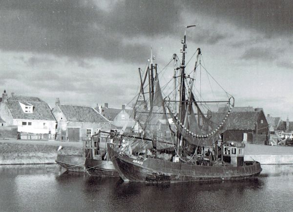 Voor de Arnemuidse vissers is het toch nog een goed jaar. Hier liggen enkele schepen afgemeerd aan het Hoofd. Het tweede huisje van links is de woning van havenmeester H. Boone. Rechts de scheepswerf. (Uit collectie Jhr. W.L den Beer Poortugael, Veere).