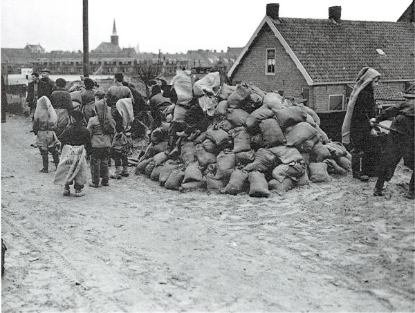 Zakken zand vullen bij de spoorwegovergang Schuttershof/Singel.