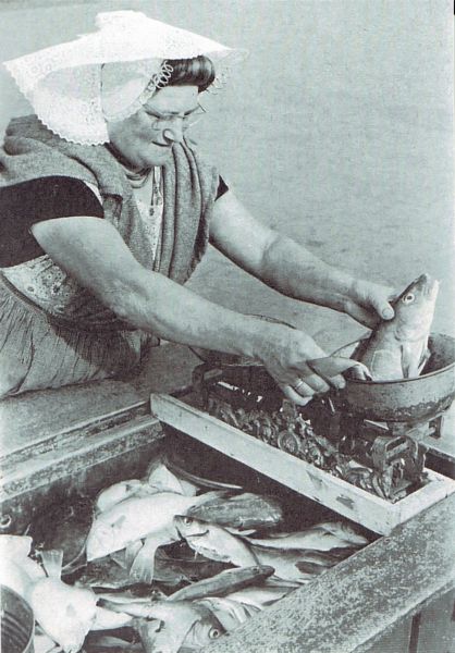 Visleurster G. van de Gruiter weegt een kabeljauw af uit haar welvoorziene viskar.