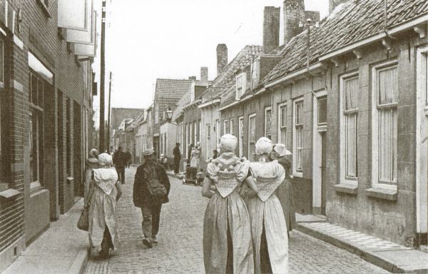 De Westdijkstraat in de toestand vóór de sanering. Links de bakkerij van bakker De Jager, later van bakker Riemens. Op de hoek van ‘het Leeuwertje’ de winkel/werkplaats van K. Marteijn en daarnaast de woninginrichting van de gebroeders J.L. en C. Joosse.