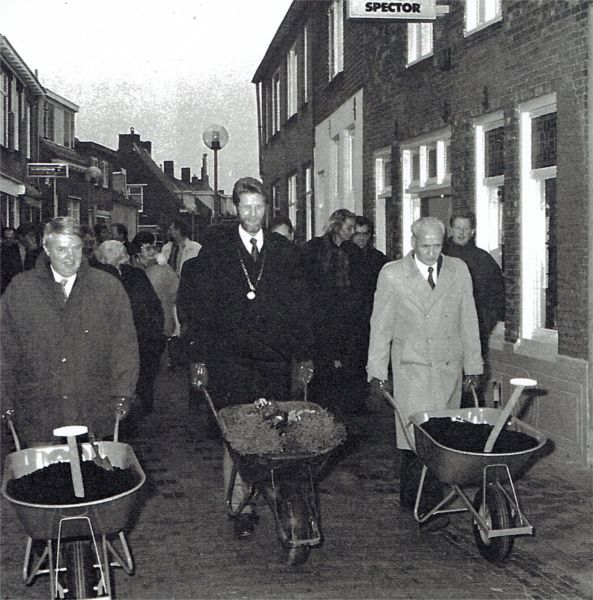 Met kruiwagens vol potaarde, viooltjes en coniferen voltooit het college van burgemeester en wethouders de verfraaiing van de vernieuwde Langstraat. V.l.n.r wethouder W. Bezemer, burgemeester H. Visser en wethouder J. van Belzen.