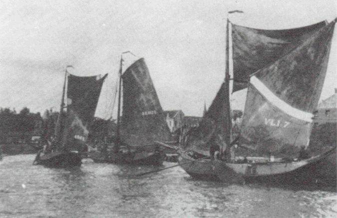 De vissersvloot zeilt de Vlissingse haven binnen.